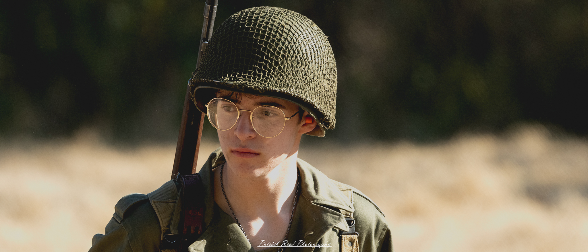 "Portrait of a U.S. GI (Government Issue) soldier, embodying the spirit of bravery and dedication during World War II. The soldier is dressed in a classic military uniform with patches, wearing a standard helmet. Their expression reflects determination and pride, encapsulating the essence of those who served. The background features muted tones, drawing attention to the soldier's face, symbolizing the sacrifice and commitment of American service members during this critical period in history."